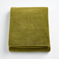 Folded olive green HG Signature bath sheet made of zero-twist cotton with matching bias piping.