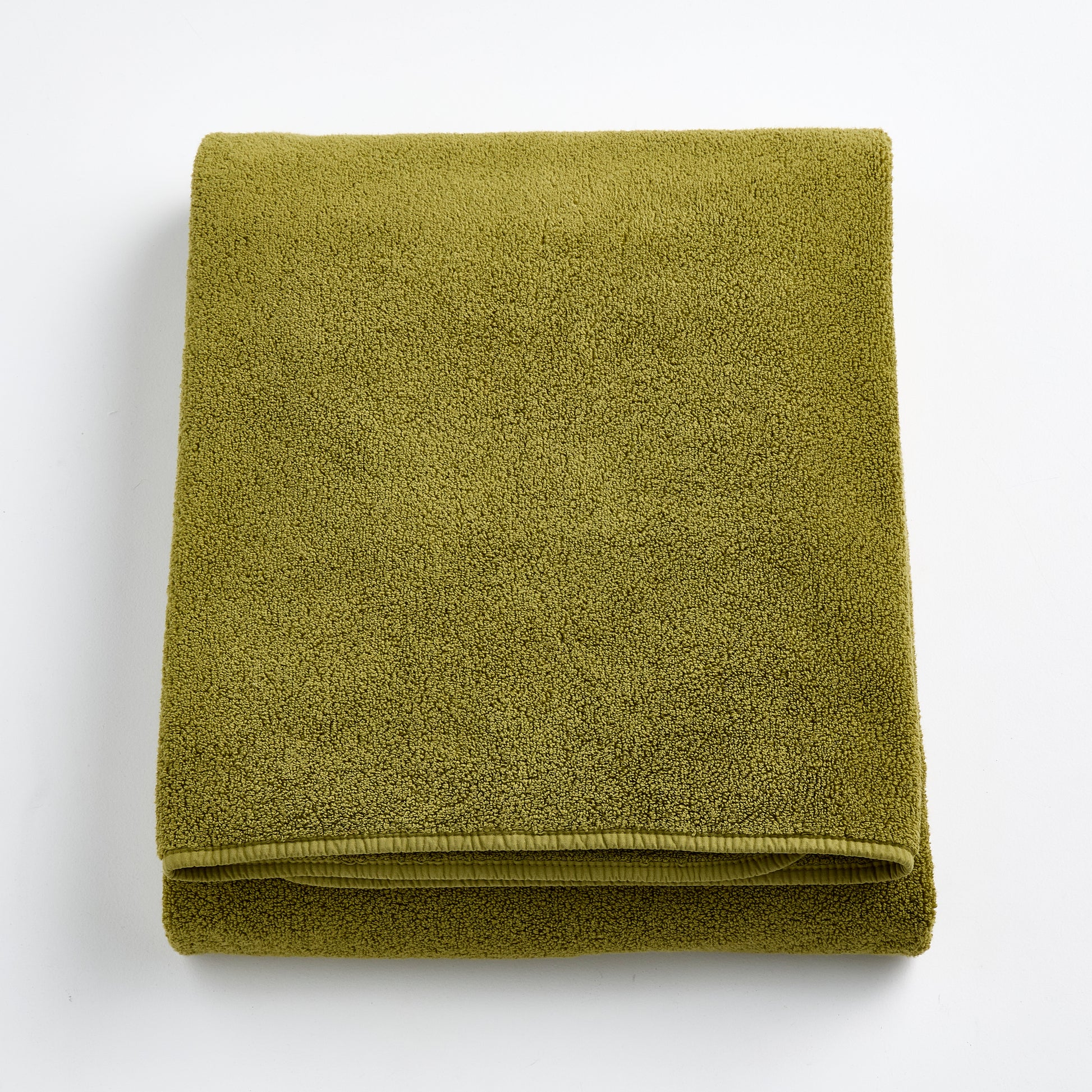 Folded olive green HG Signature bath sheet made of zero-twist cotton with matching bias piping.