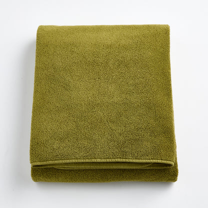 Folded olive green HG Signature bath sheet made of zero-twist cotton with matching bias piping.