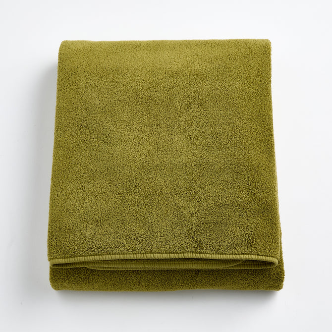 Folded olive green HG Signature bath sheet made of zero-twist cotton with matching bias piping.