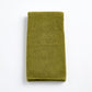 Olive green zero-twist cotton hand towel, 20x30 inches, featuring textured terry fabric and finished bias piping.