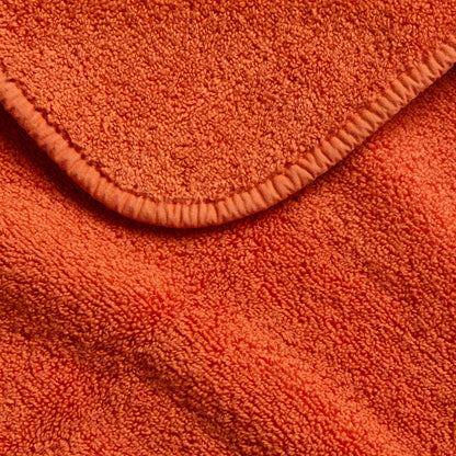 Pumpkin orange Signature bath sheet with a soft, plush cotton terry texture and a finished stitched hem edge.