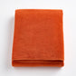 Folded pumpkin orange Signature bath sheet made of plush, absorbent cotton terry fabric.
