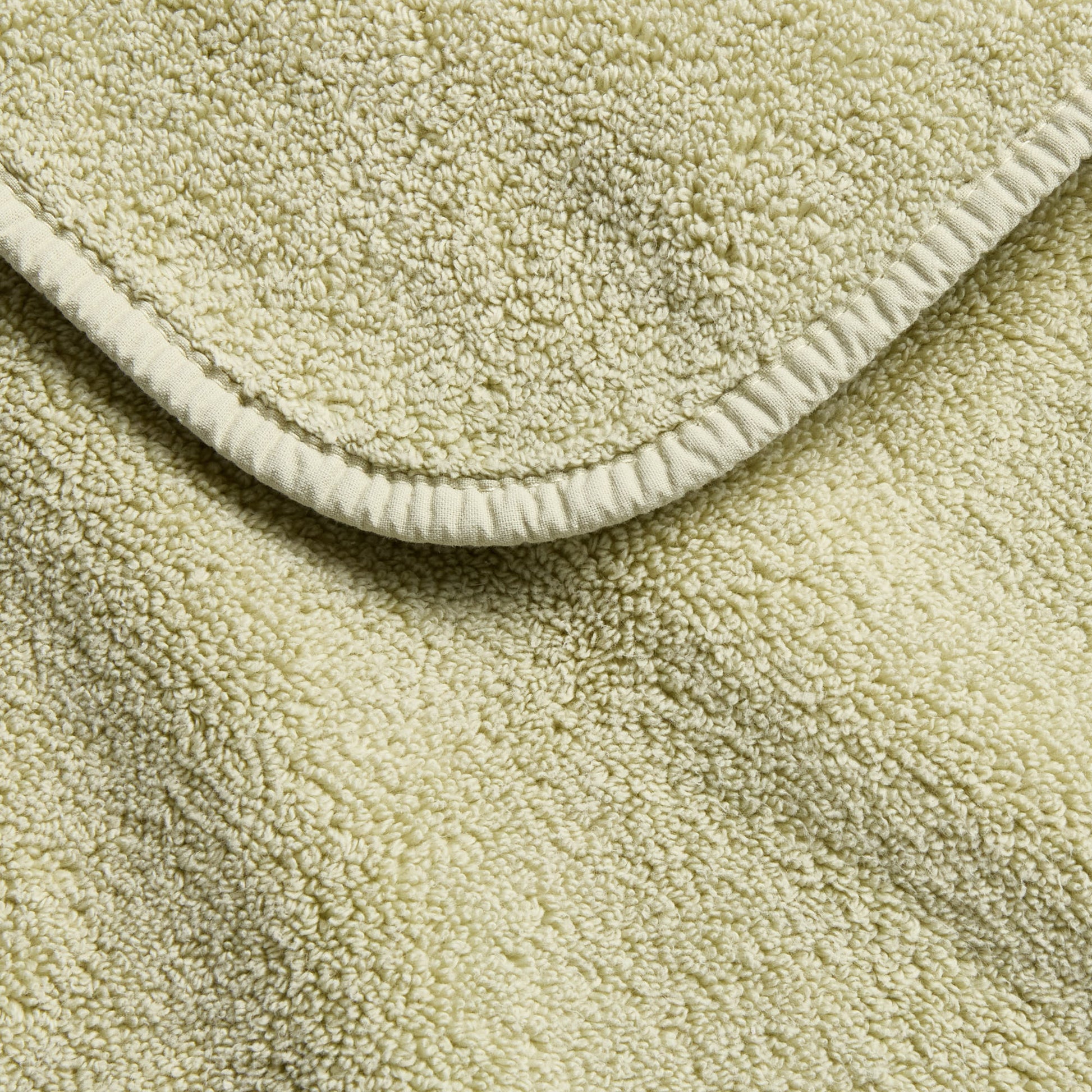 Sage green Signature bath towel featuring a soft, absorbent cotton terry texture and a finished stitched edge.