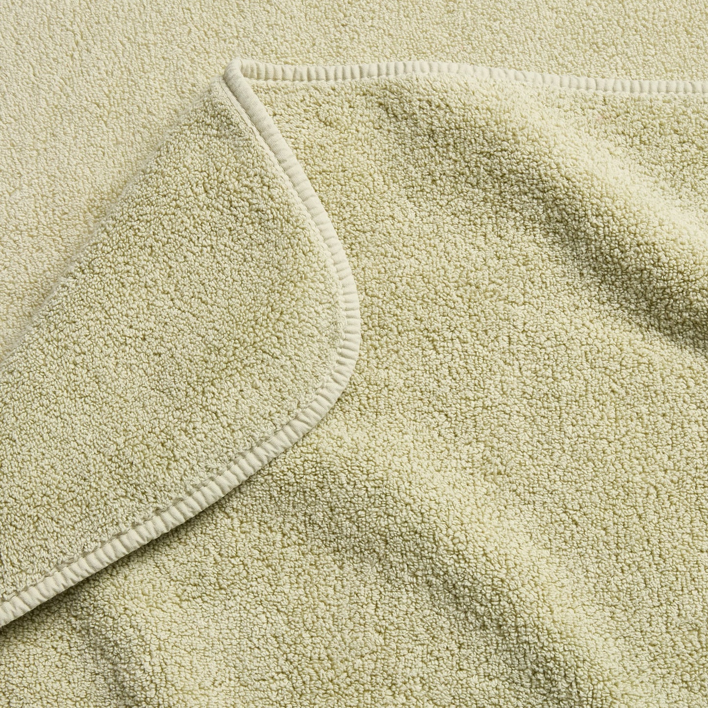Sage green Signature bath towel with a soft, plush terry texture and a finished stitched hem.