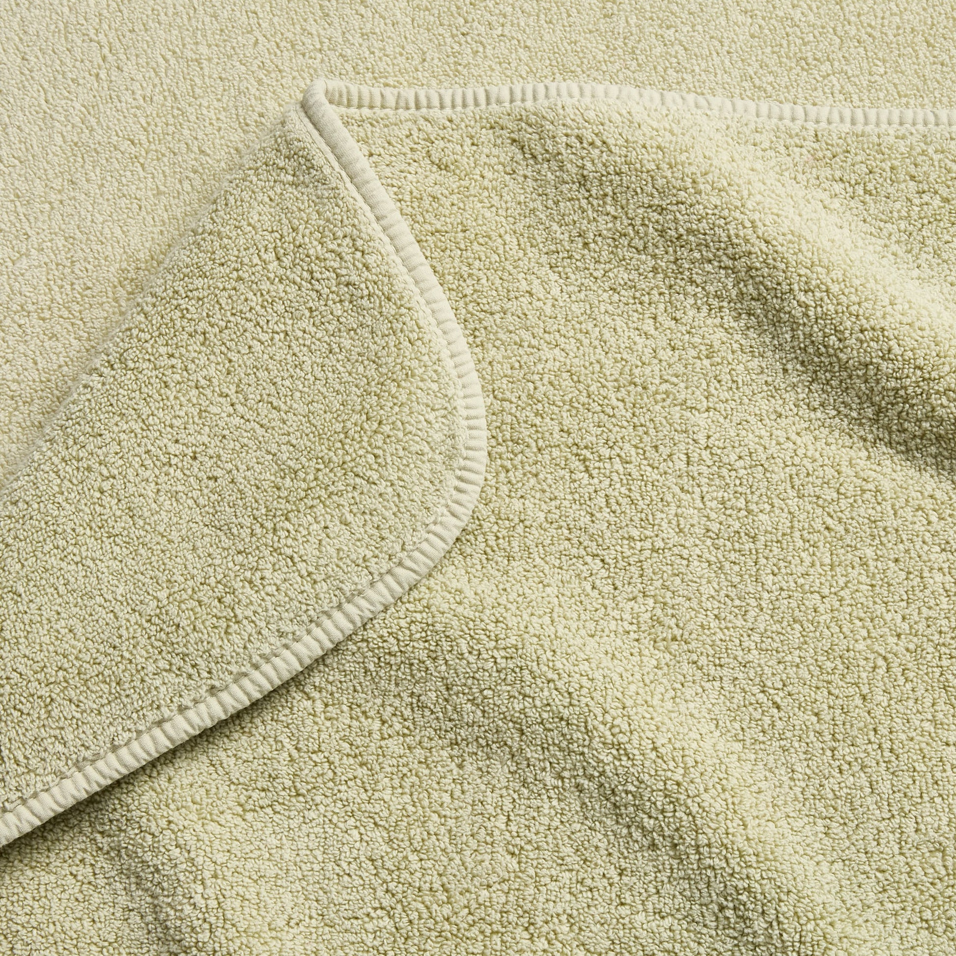 Sage green Signature bath towel with a soft, plush terry texture and a finished stitched hem.