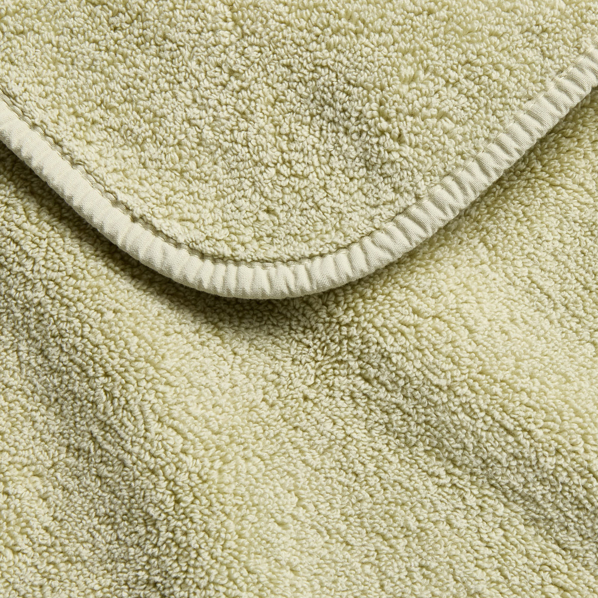 Sage green cotton hand towel with a soft, plush terry texture and a neatly finished stitched hem.