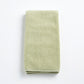 Sage green Signature hand towel made of soft, textured cotton terry cloth, folded neatly on a white background.