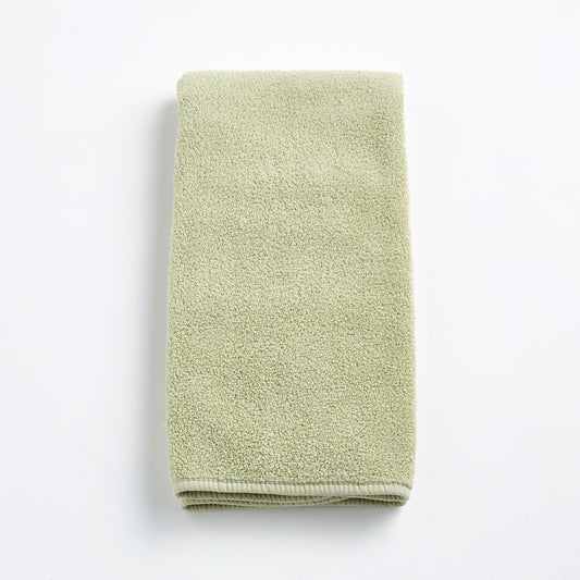 Sage green Signature hand towel made of soft, textured cotton terry cloth, folded neatly on a white background.