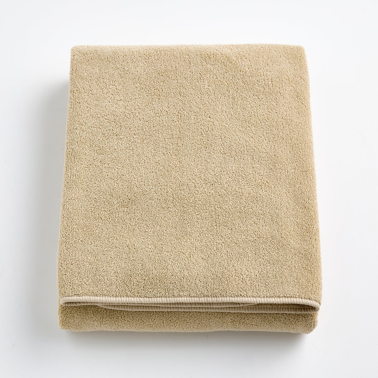Folded sand-colored Signature bath sheet in plush, absorbent cotton terry fabric with a clean hemmed edge.