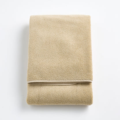 Folded sand-colored Signature bath towel in plush, high-quality cotton terry fabric with a clean hemmed edge.
