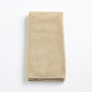 Folded sand-colored Signature hand towel made of plush, absorbent cotton terry fabric on a white background.