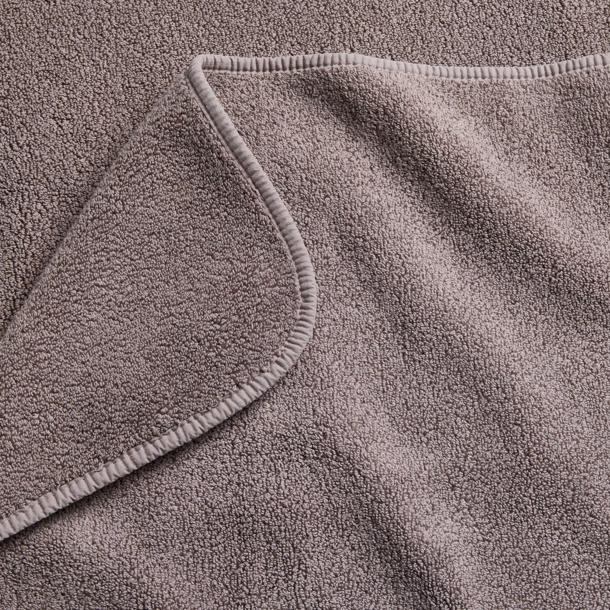 Stone gray Signature bath sheet featuring a soft, absorbent cotton terry texture and a finished stitched hem.