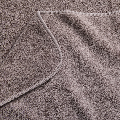 Stone gray Signature bath sheet featuring a soft, absorbent cotton terry texture and a finished stitched hem.