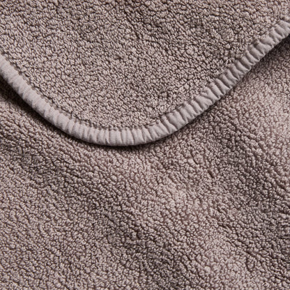 Stone grey HG Signature washcloth featuring a plush, textured cotton terry fabric with a finished stitched edge.