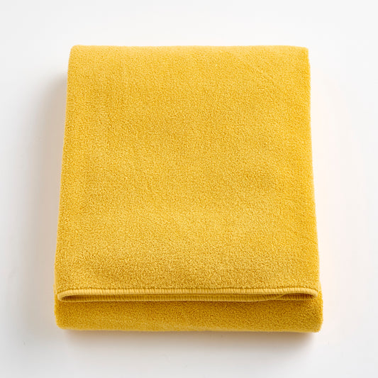 Folded bright yellow Signature bath sheet made of soft, absorbent cotton terry fabric.