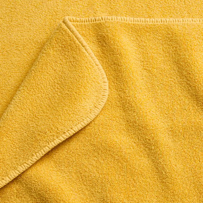 Bright yellow Signature bath sheet with a soft, plush cotton terry texture and finished stitched edges.