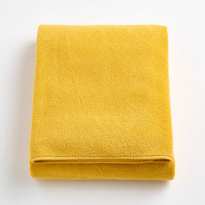 Folded bright yellow Signature bath sheet made of soft, absorbent cotton terry fabric.