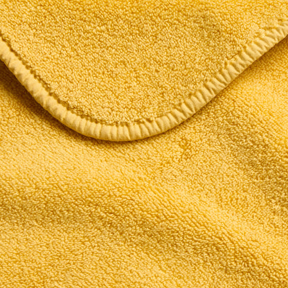 Bright yellow cotton hand towel with a soft terry texture and finished stitched hem detail.