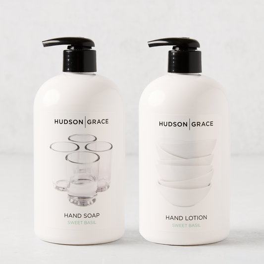 Two white Hudson Grace Sweet Basil bottles with black pumps: Hand Soap with glasses graphic, Hand Lotion with bowls graphic.