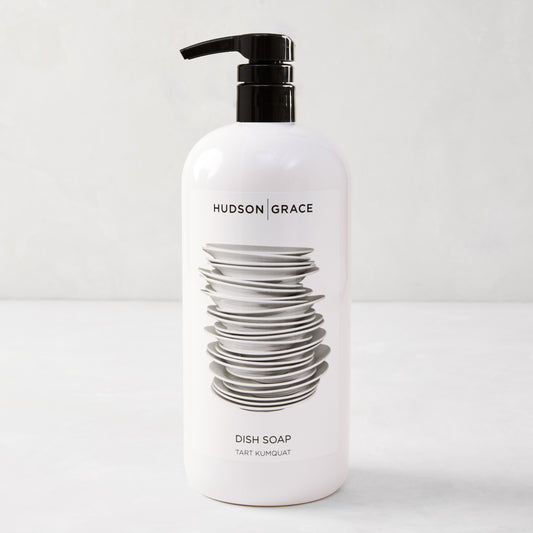 White HG Tart Kumquat Dish Soap bottle with a black pump, featuring a stack of plates design.