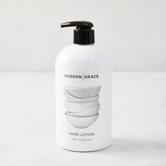 White HG Tart Kumquat Hand Lotion, 16 oz, with black pump and stacked bowls design.