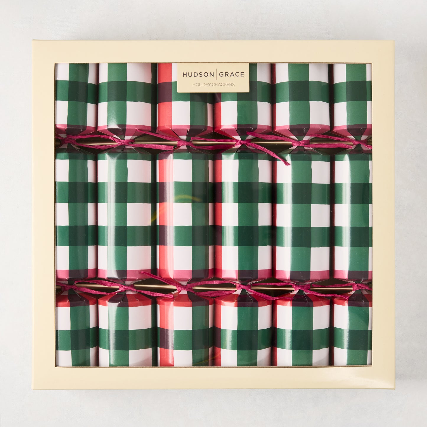 Hudson Grace Holiday Gingham Christmas Crackers, red and green plaid, tied with pink ribbon, in a beige box.