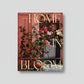 Hardcover "Home in Bloom" coffee table book with gold lettering and a floral interior design cover.