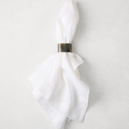 Horn napkin ring with unique natural variations on a white linen napkin.