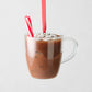 Glass hot cocoa Christmas ornament with marshmallows, peppermint stick, and red ribbon.