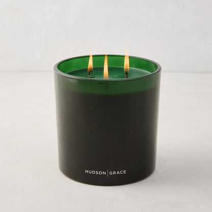 Hudson Grace Aspen Scented 3-Wick Candle in a dark green glass vessel with three lit wicks.
