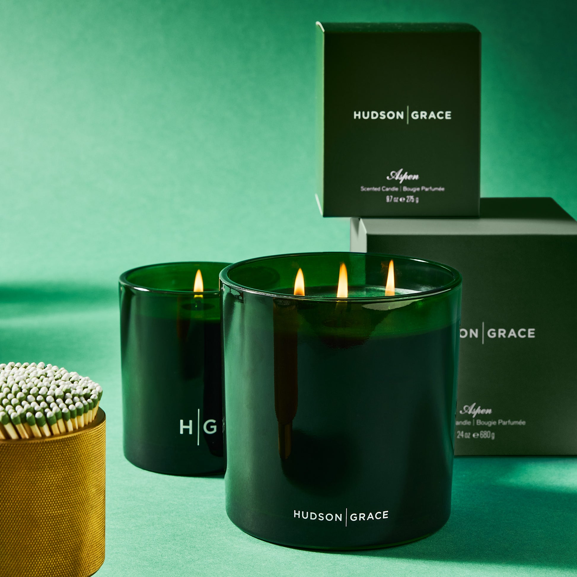 Hudson Grace Aspen scented candles in dark green glass vessels, one 3-wick, with matching boxes and matches.
