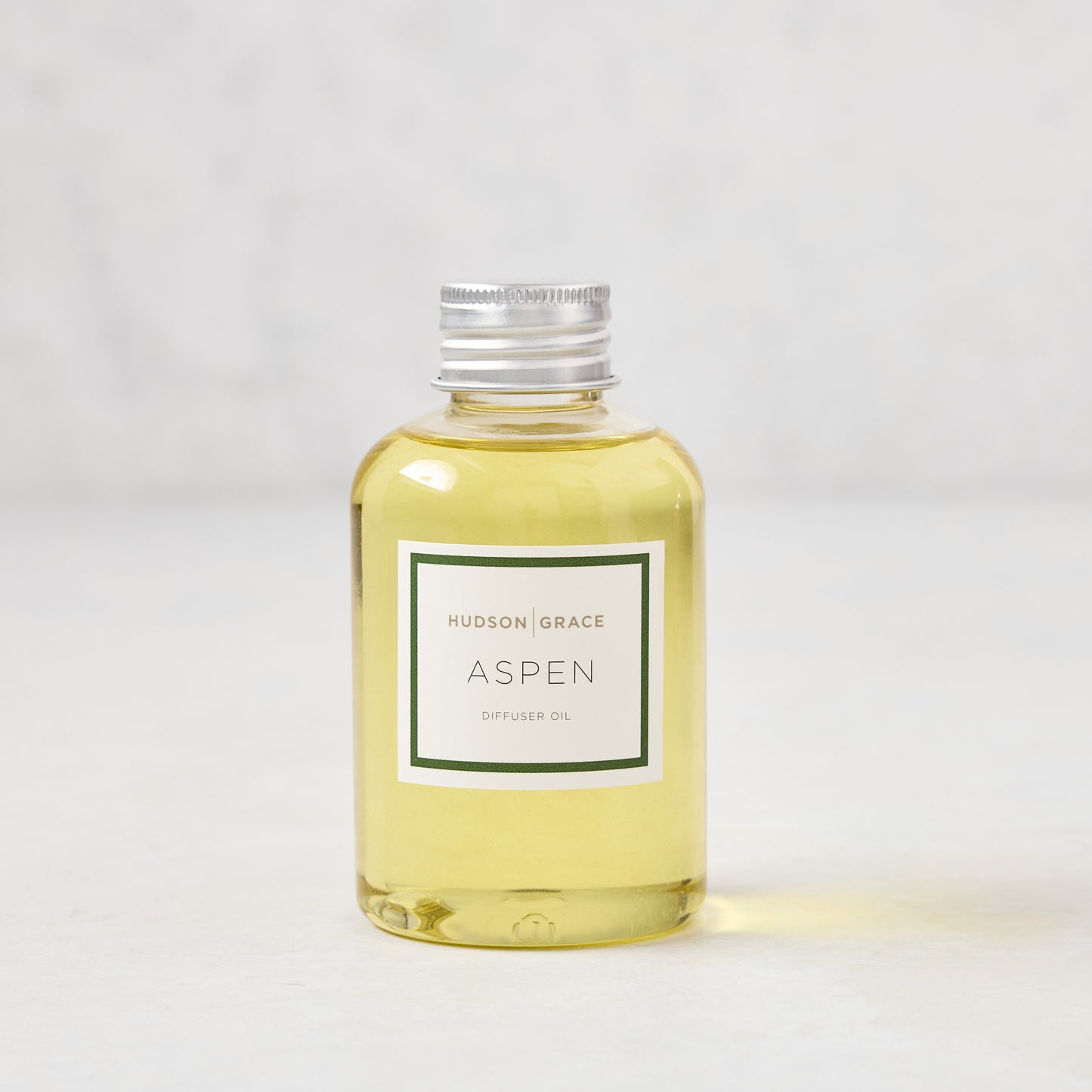 Hudson Grace Aspen Diffuser Oil Refill, 4oz clear glass bottle with light yellow oil and silver cap.