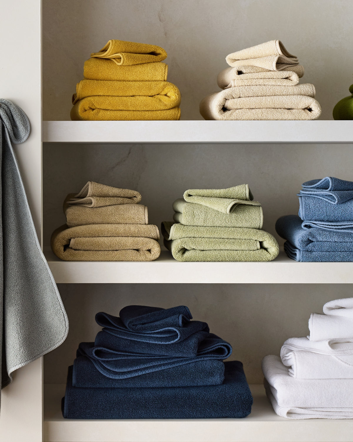 Hudson Grace bath towel collection folded on shelves in a range of colors