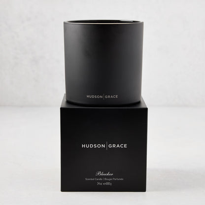 Hudson Grace Bleecker Scented 3-Wick Candle in a matte black glass vessel on its matching black gift box.