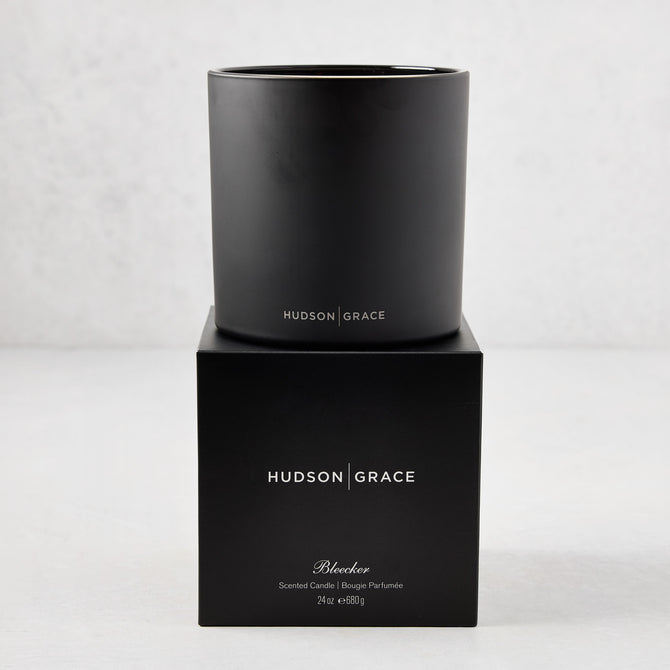 Hudson Grace Bleecker Scented 3-Wick Candle in a matte black glass vessel on its matching black gift box.