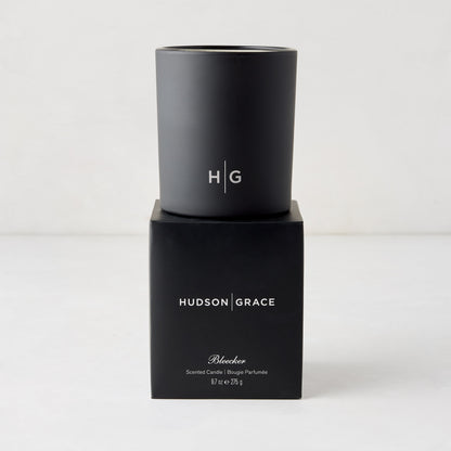 Hudson Grace Bleecker Scented Candle, black matte glass vessel with HG logo, on its black box.