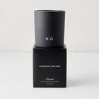 Hudson Grace Bleecker Scented Candle, black matte glass vessel with HG logo, on its black box.