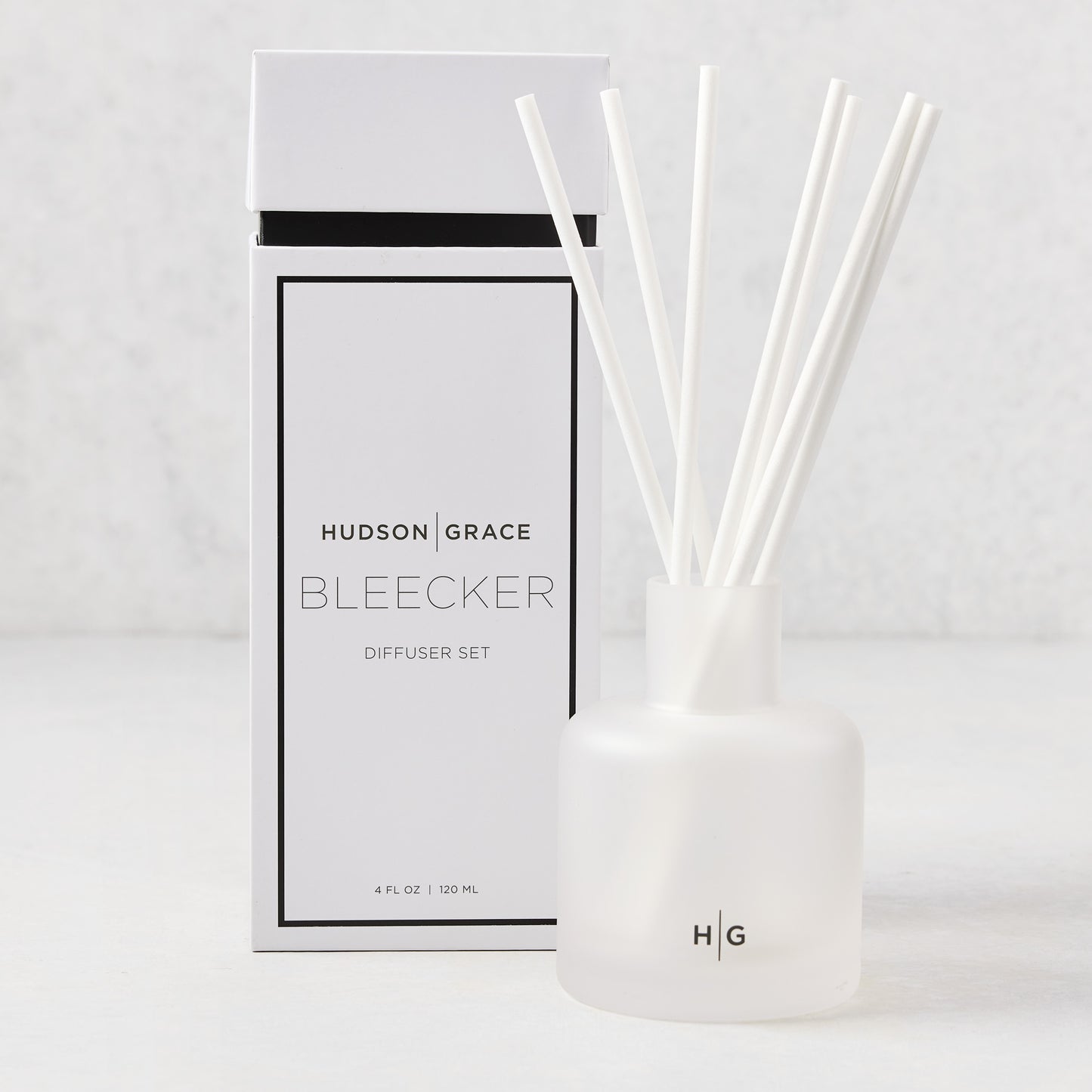 Hudson Grace Bleecker Scented Reed Diffuser set with frosted glass vessel, white reeds, and white box.