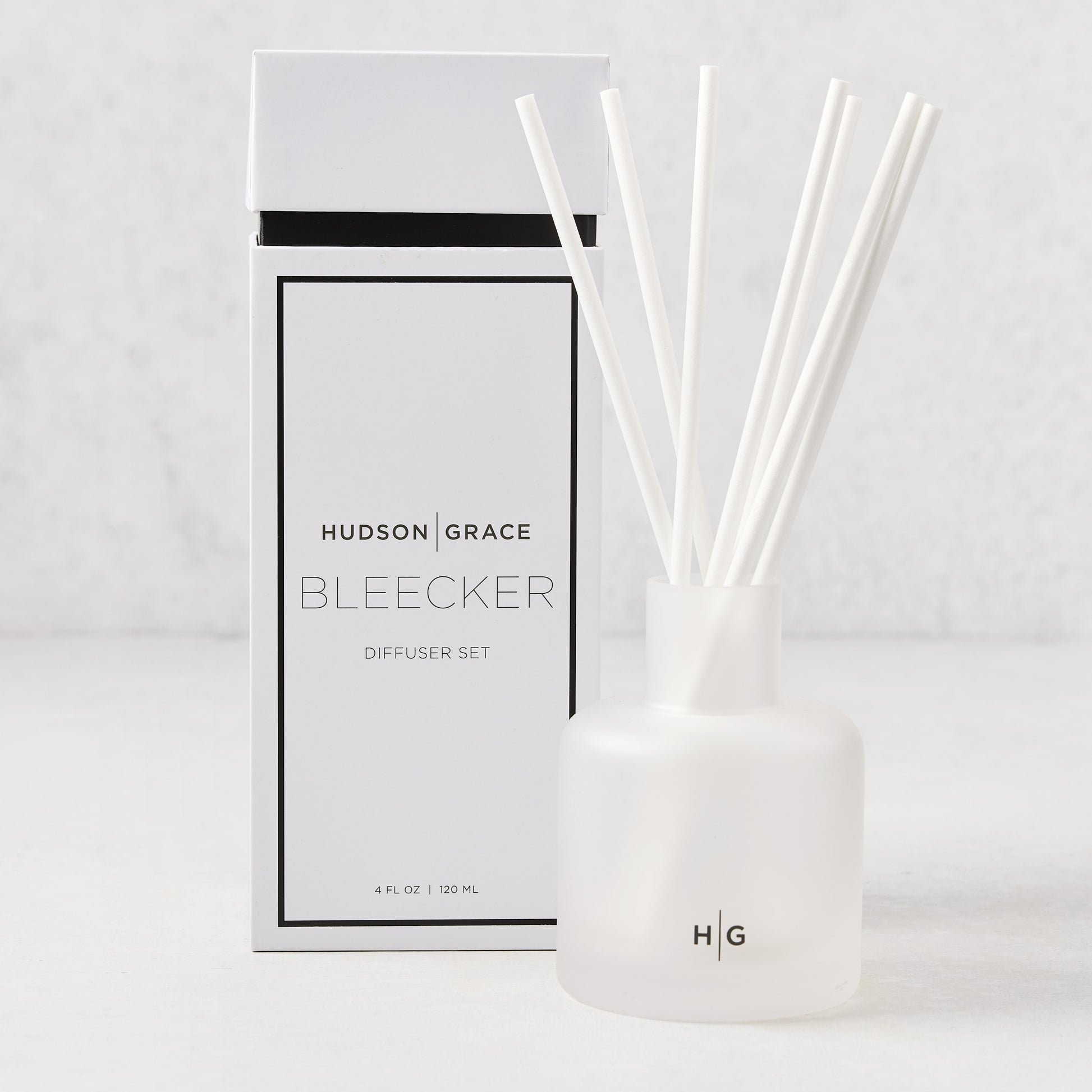 Hudson Grace Bleecker Scented Reed Diffuser set with frosted glass vessel, white reeds, and white box.