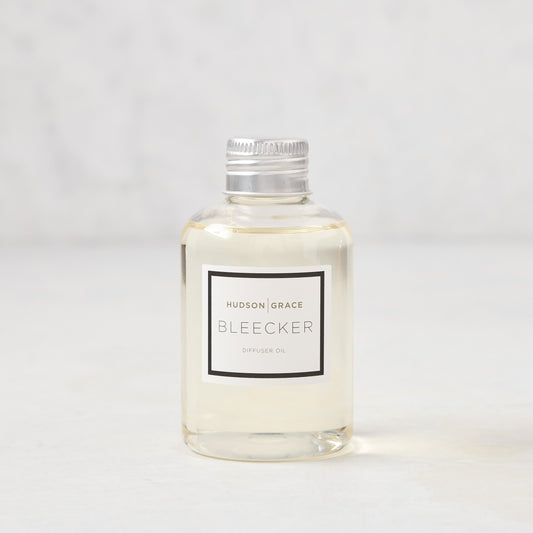 Hudson Grace Bleecker Scented Reed Diffuser Oil Refill, clear glass bottle with silver cap and white label.