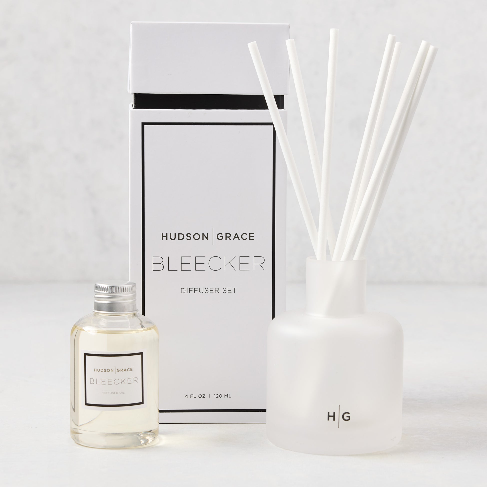 Hudson Grace Bleecker Scented Reed Diffuser set with frosted glass vessel, oil bottle, and white reeds.