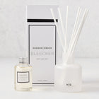 Hudson Grace Bleecker Scented Reed Diffuser set with frosted glass vessel, oil bottle, and white reeds.