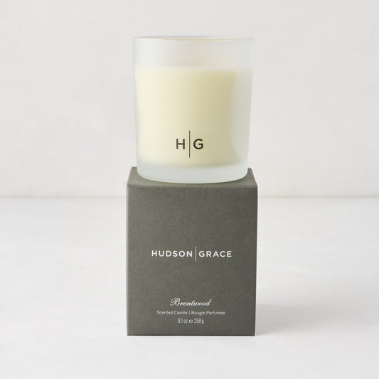 Hudson Grace Brentwood Scented Candle in a frosted glass vessel with HG logo, on a dark gray box.