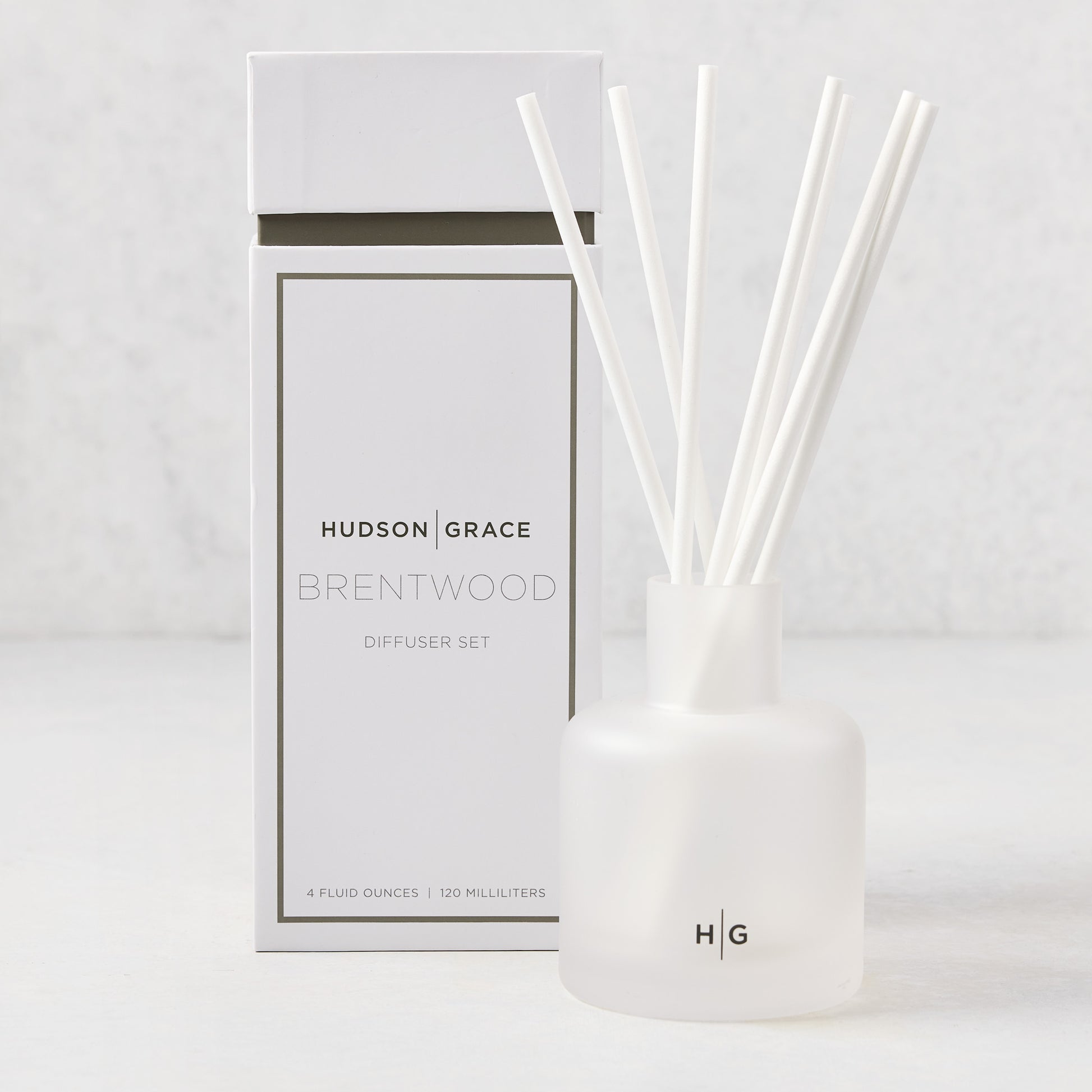 Hudson Grace Brentwood scented reed diffuser set with frosted glass vessel, white reeds, and white box.