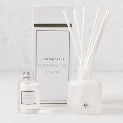 Hudson Grace Brentwood Scented Reed Diffuser set: frosted glass vessel with white reeds, clear oil bottle, and white box.