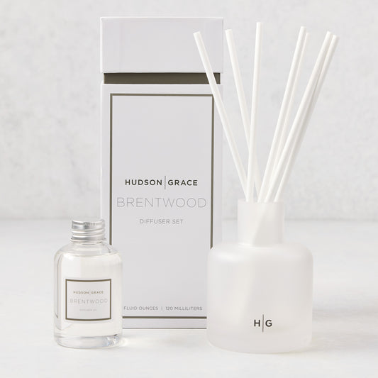 Hudson Grace Brentwood Scented Reed Diffuser set: frosted glass vessel with white reeds, clear oil bottle, and white box.