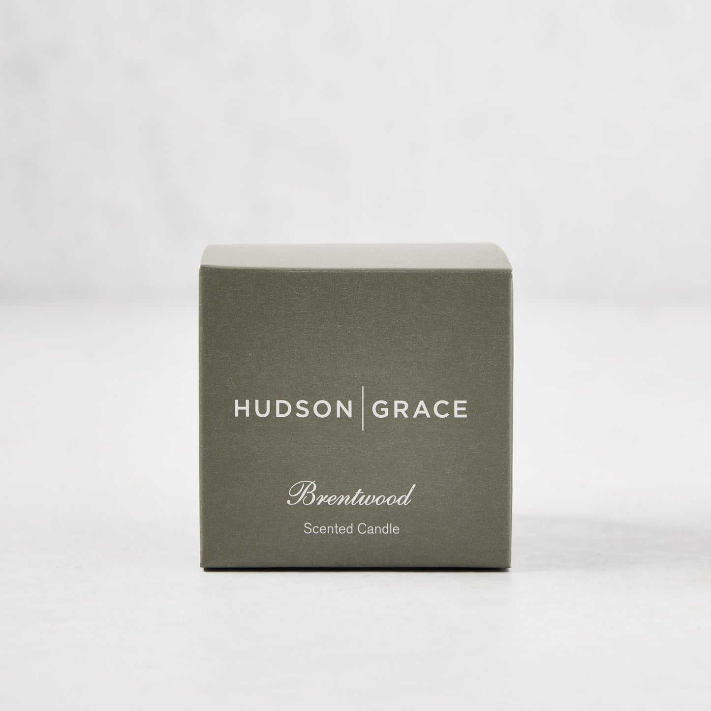 Hudson Grace Brentwood Scented Votive Candle in a sage green box with white text.