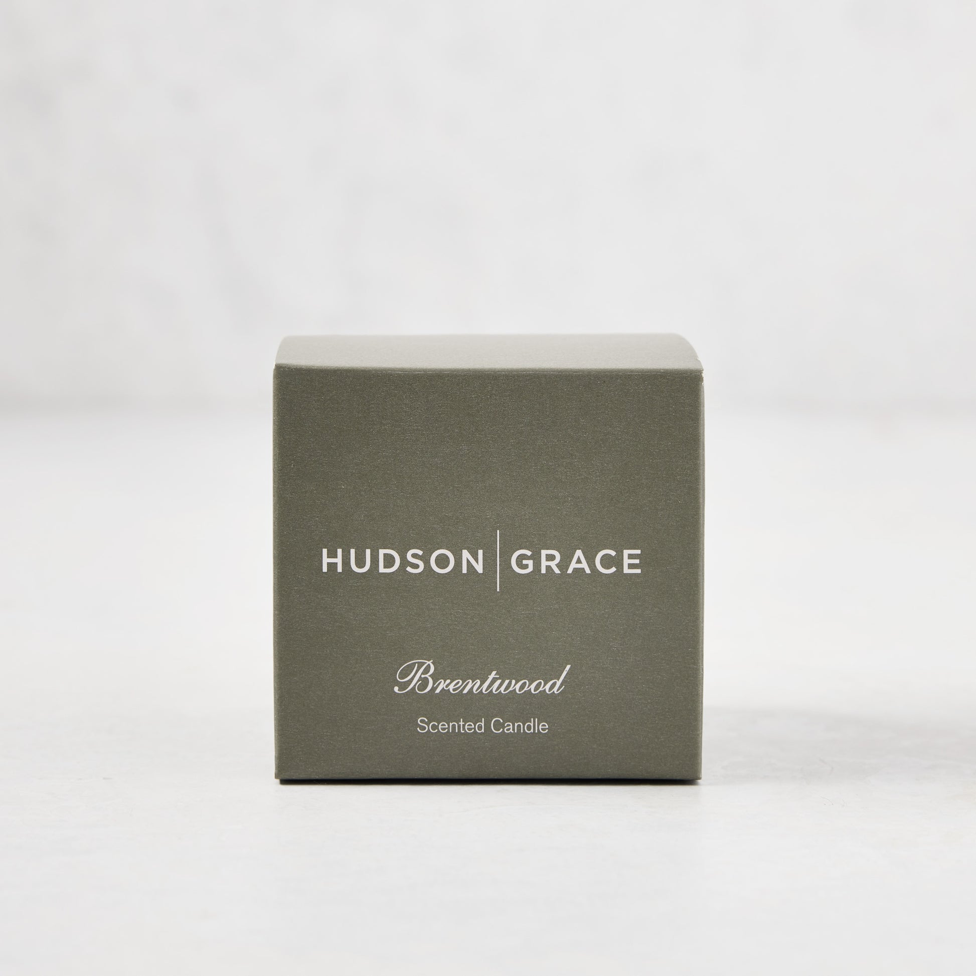 Hudson Grace Brentwood Scented Votive Candle in a sage green box with white text.