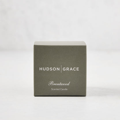 Hudson Grace Brentwood Scented Votive Candle in a sage green box with white text.